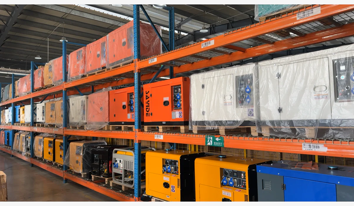 Open-frame and enclosed generators displayed and stored on warehouse racks, with some units wrapped on pallets